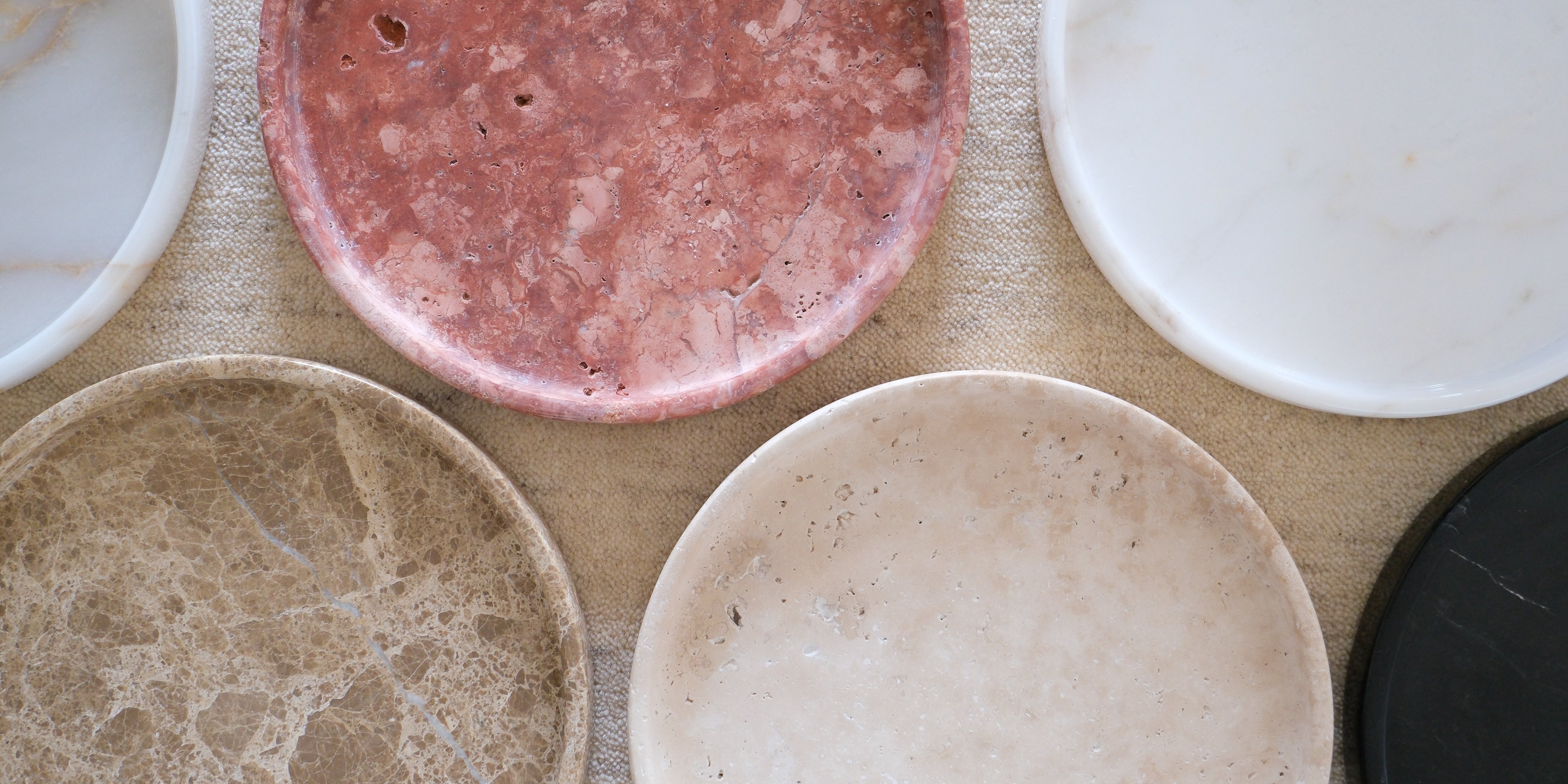 Collection of six Raya marble trays in various colors, showcasing their elegant round design and polished finish.