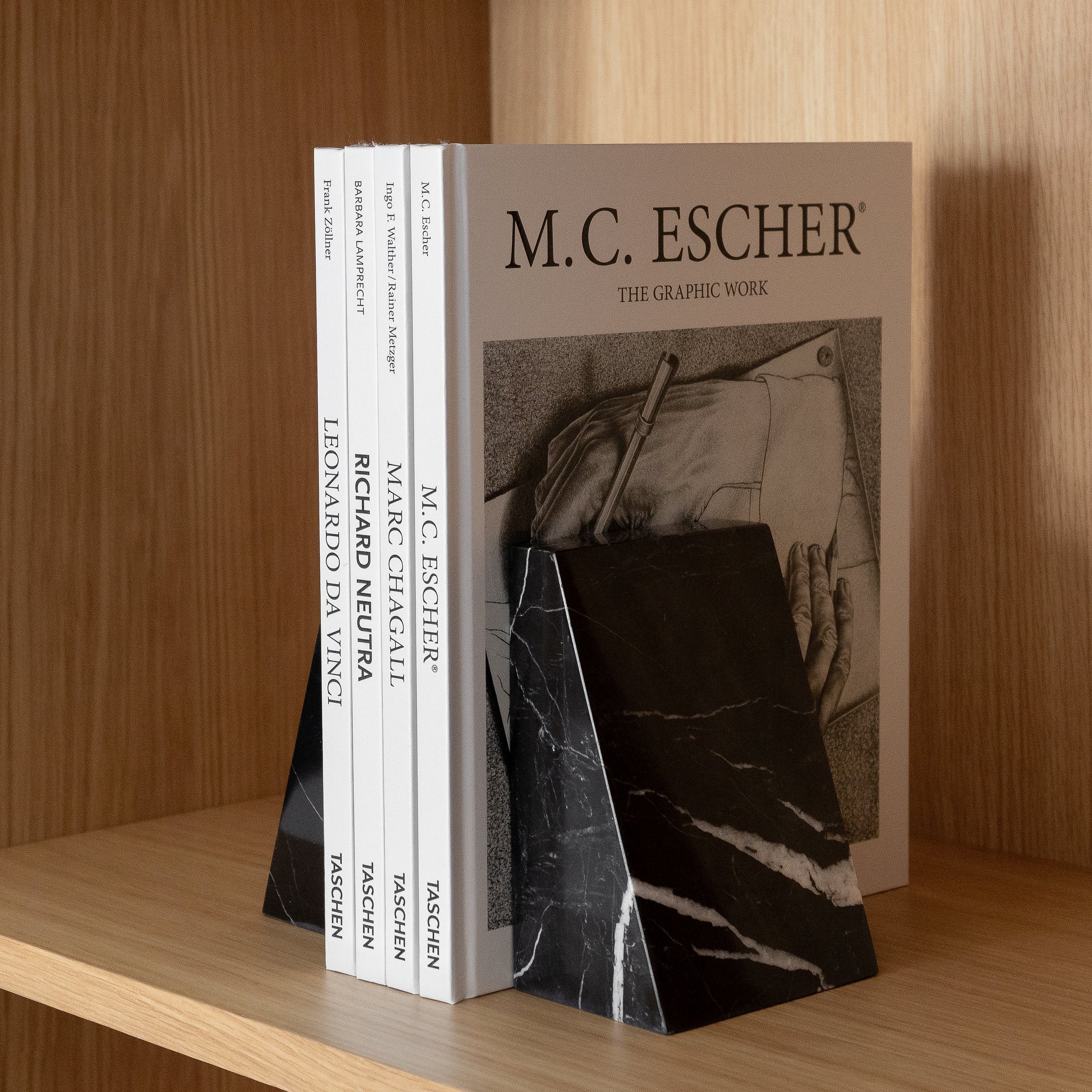 Eli marble bookends in black with unique veining, styled to hold books elegantly on a modern home office shelf.