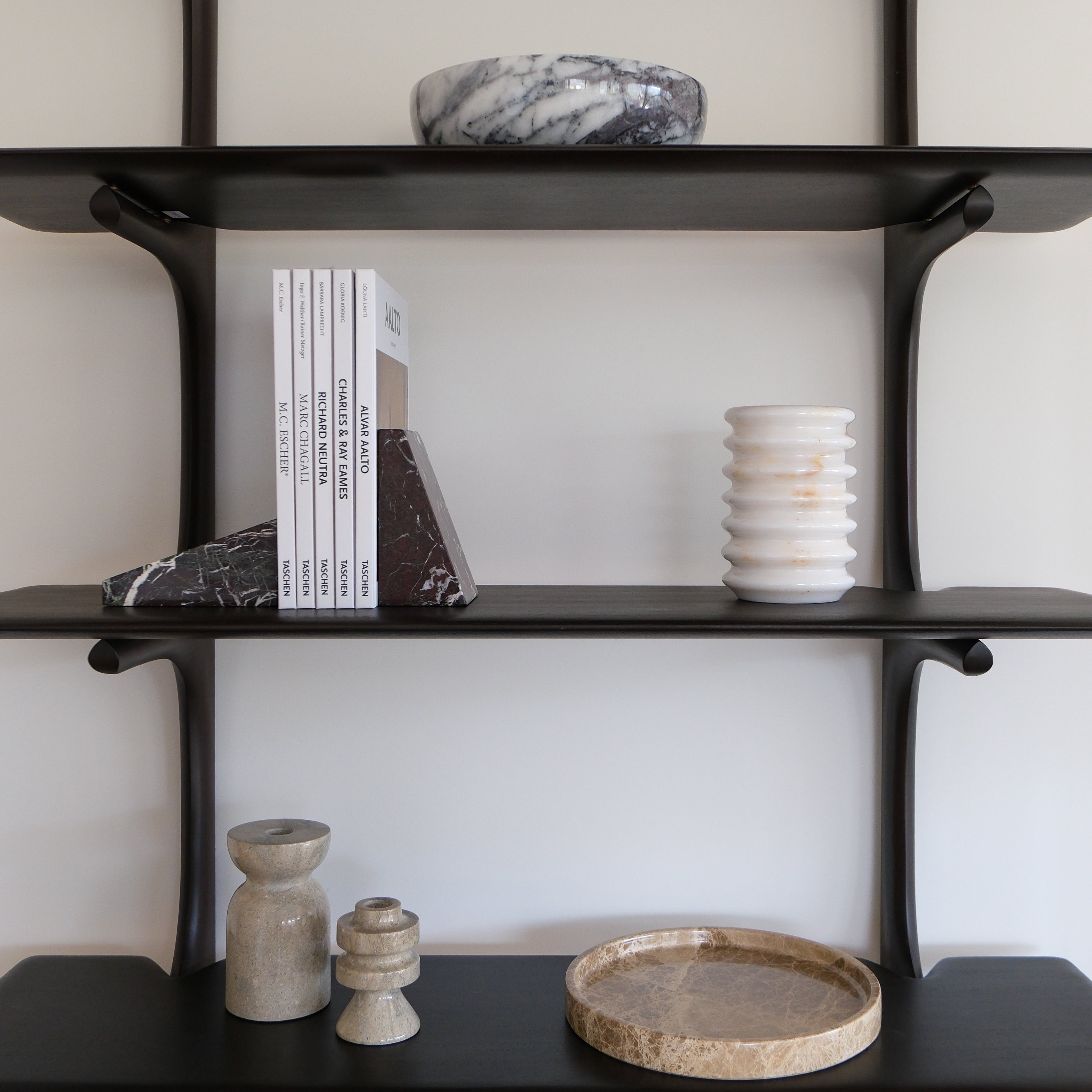 Styled shelf featuring the Levi marble bowl, Raya marble tray, Eli marble bookends in cherry, and Luca candle holders, creating a cohesive modern decor display.